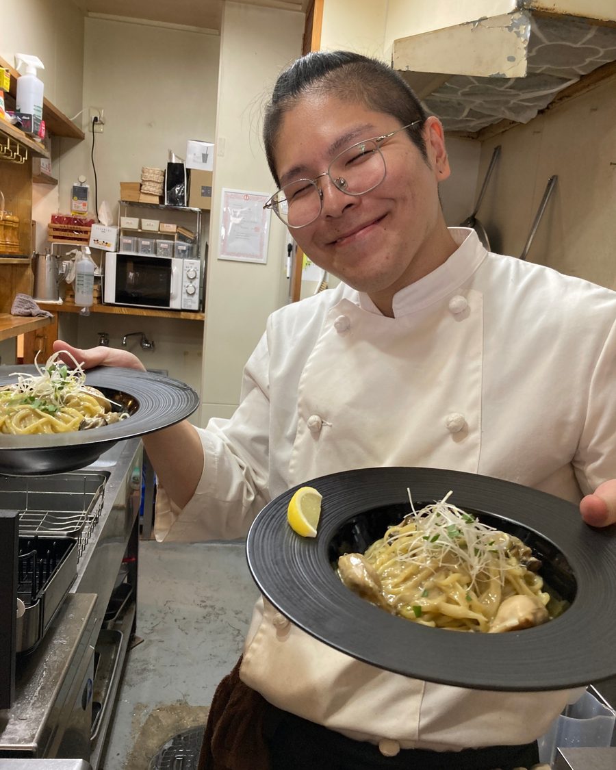 パスタを持って笑うシェフのマコト